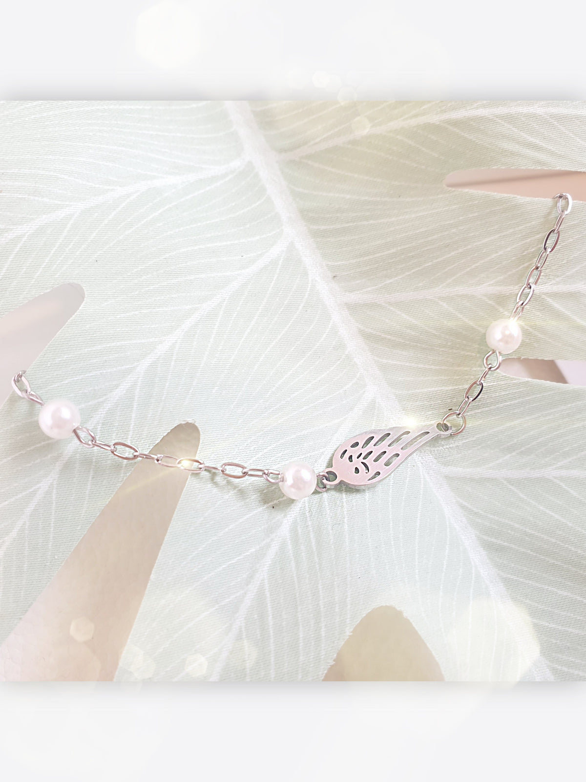 Zartes Armband aus Edelstahl mit Engelsflügel und kleinen Perlen